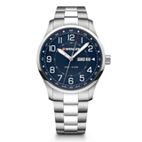 A stainless steel wrist watch with a dark blue dial, silver-tone metal case and bracelet, featuring large white Arabic numerals, a day and date window, and a red brand logo on the dial.