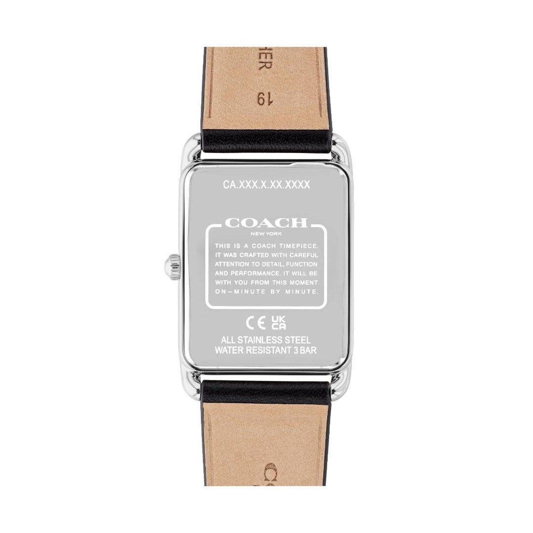 The back view of a Coach wristwatch with a silver stainless steel case and a light brown leather strap, showing technical specifications printed on the metal.