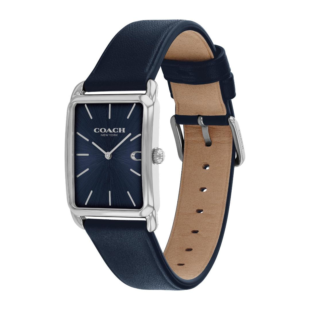 A Coach wristwatch with a navy blue dial and matching navy blue leather strap, featuring a silver-tone rectangular case and a tan interior lining, shown on a plain white background.