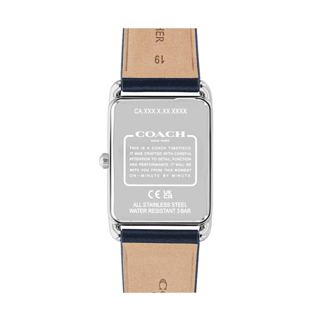 The back view of a Coach wristwatch with a silver stainless steel case and a light brown leather strap, showing technical specifications printed on the metal back.