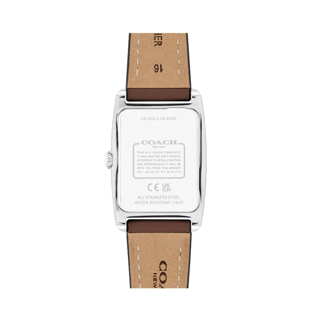The back view of a Coach wristwatch with a silver stainless steel case and a brown leather strap, showing the brand name and specifications engraved on the case.