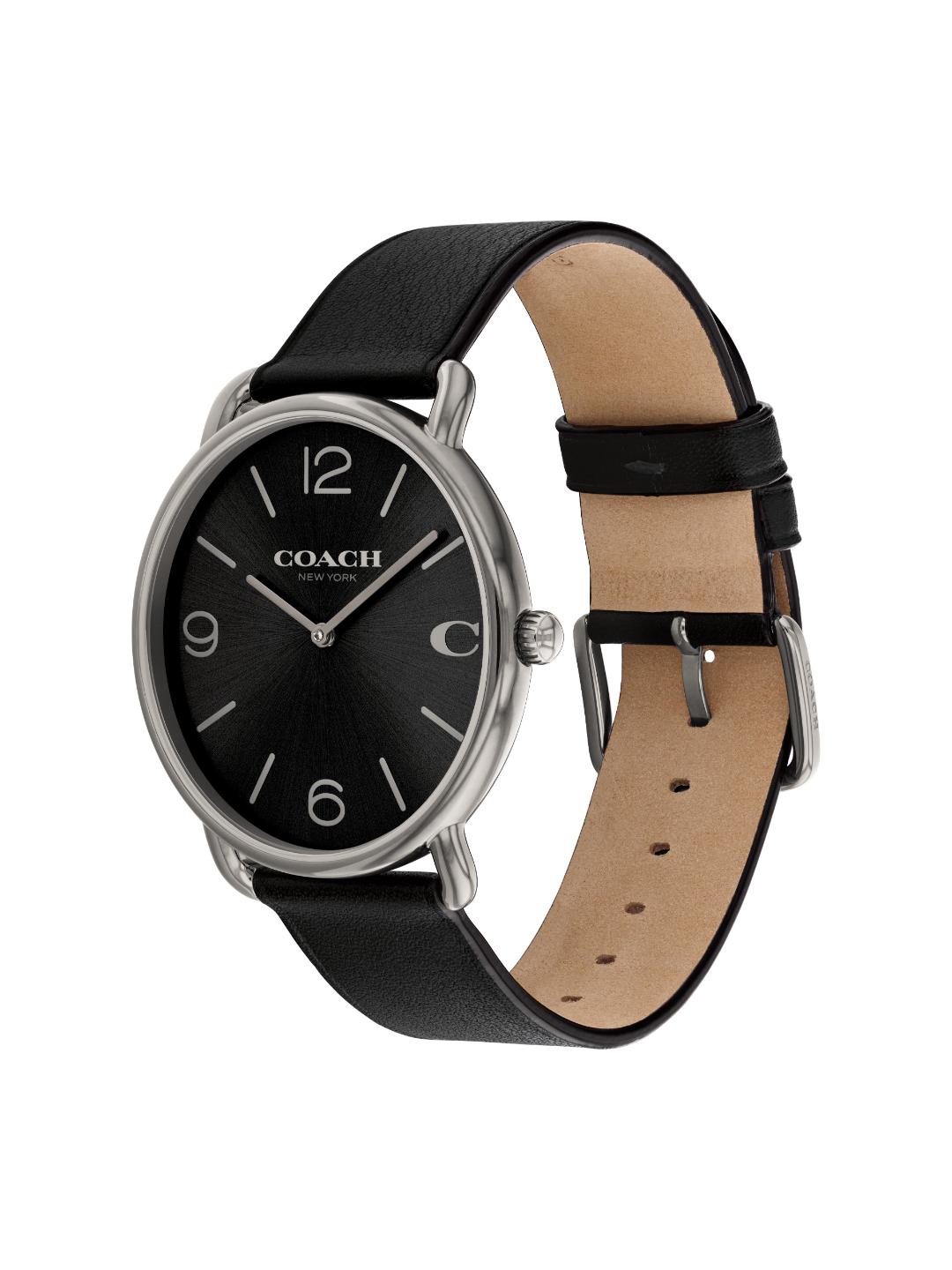 A Coach wristwatch with a black dial, silver-tone case, and a black leather strap with a tan interior, shown on a plain white background.