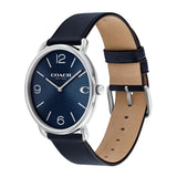 A Coach wristwatch with a navy blue dial, silver-tone case, and a dark navy blue leather strap with a tan interior, shown on a plain white background.