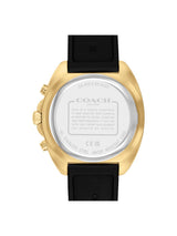 The back view of a Coach wristwatch with a gold-tone case and a black strap, showing the brushed silver-toned case back with engraved details.