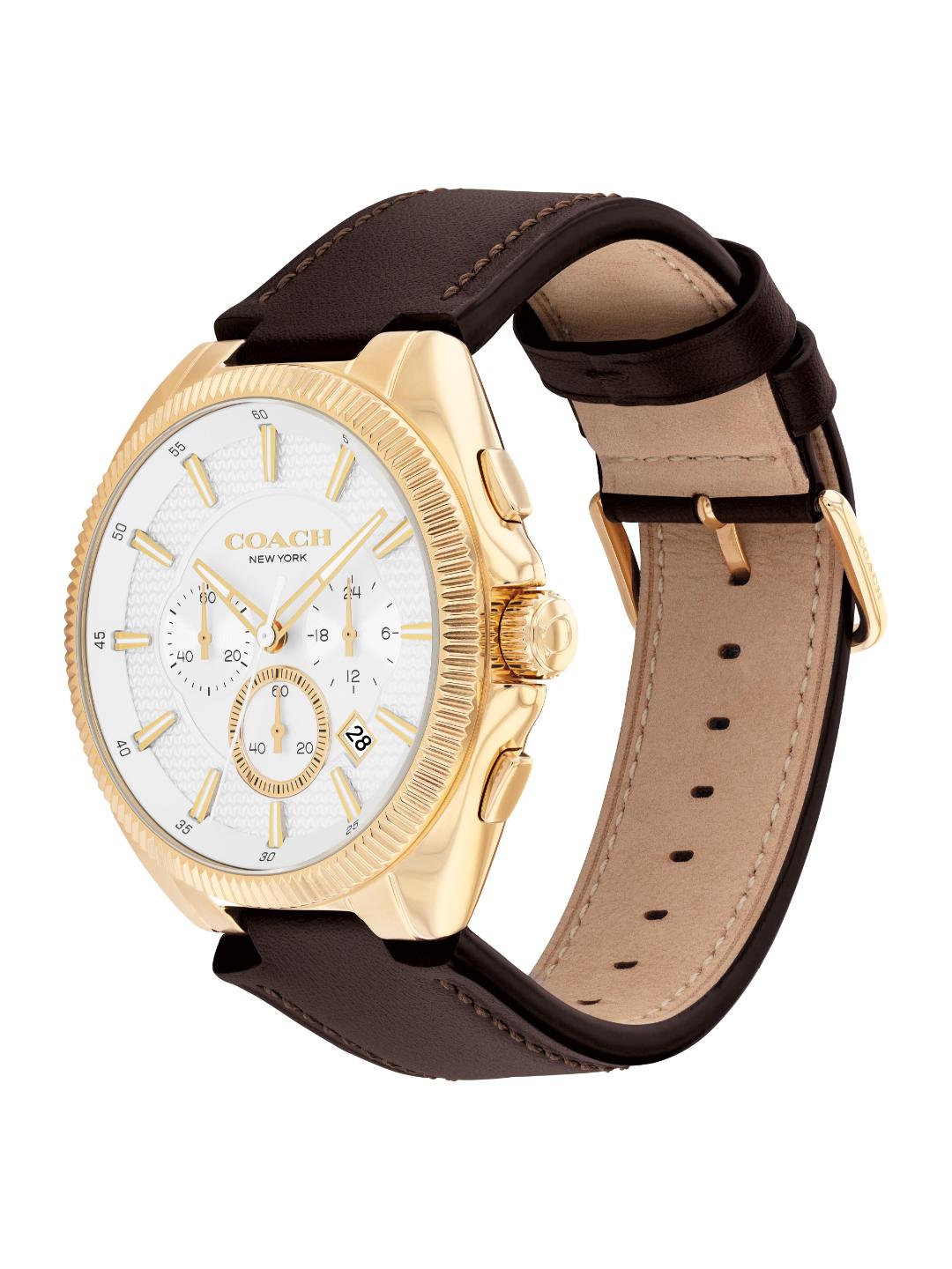 A Coach New York wristwatch with a gold-tone case, white dial, and dark brown leather strap, shown on a plain white background.