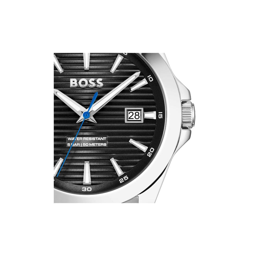 A close-up of a Hugo Boss wristwatch with a black dial, silver-tone stainless steel case, silver-tone hour markers, and a blue seconds hand on a white background.