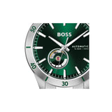 A close-up of a Hugo Boss automatic watch with a green dial, silver-tone case, and green tachymeter bezel, shown on a plain white background.