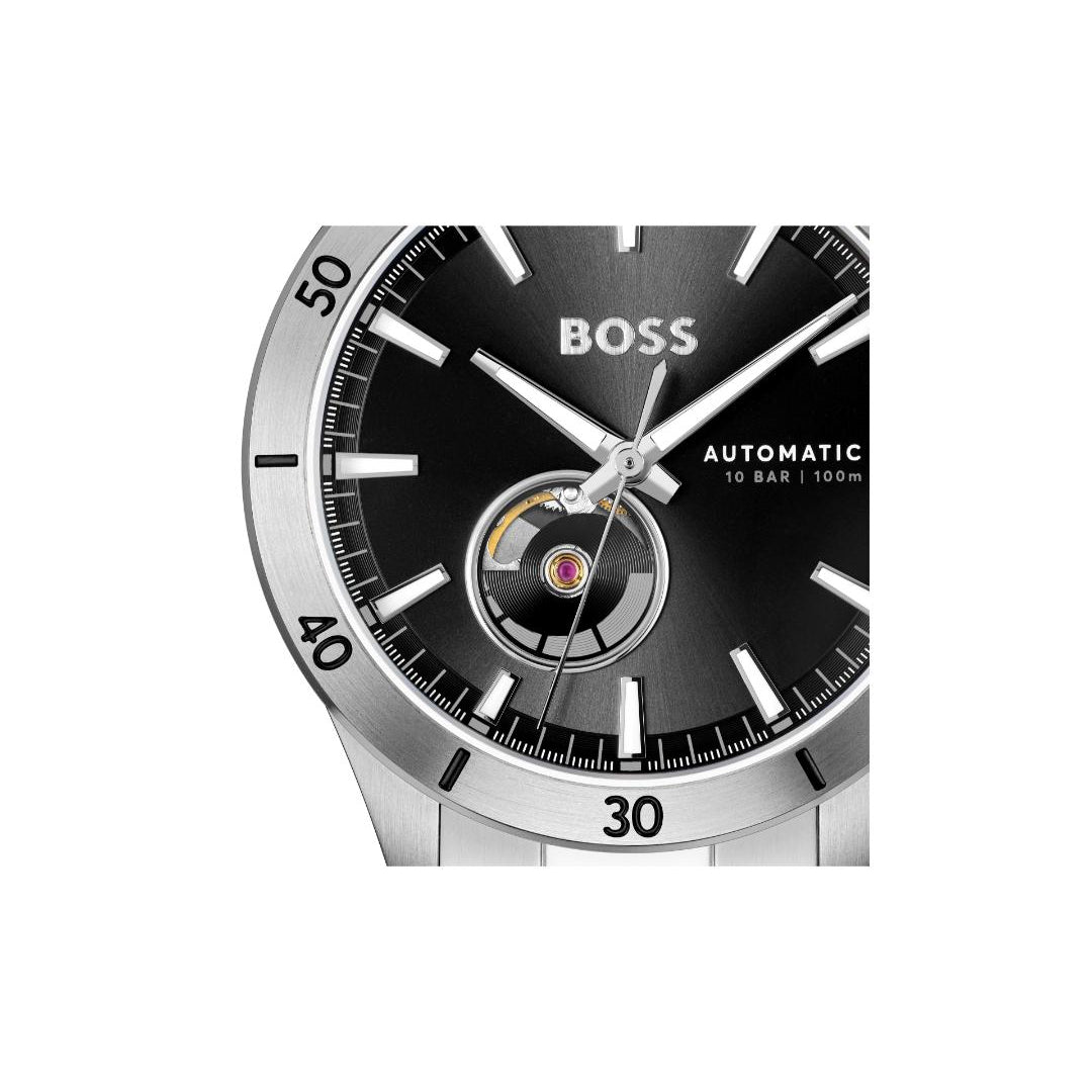 Close-up of a Hugo Boss automatic watch with a black dial, silver-tone case, and black bezel, featuring a visible tourbillon movement at the 6 o'clock position.