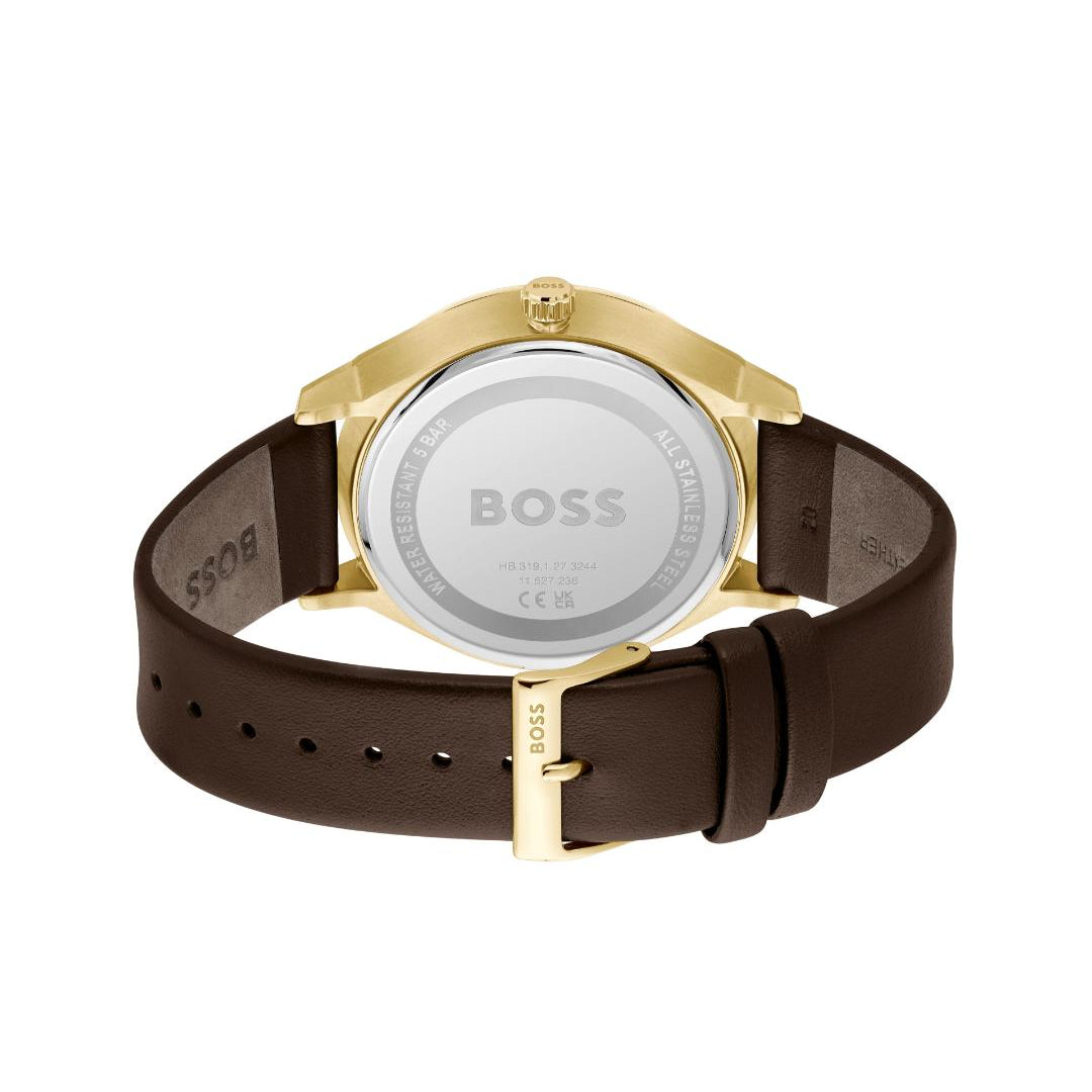 The back view of a HUGO BOSS watch with a dark brown leather strap and a gold-tone case, showing the brushed silver-tone case back engraved with the BOSS logo.