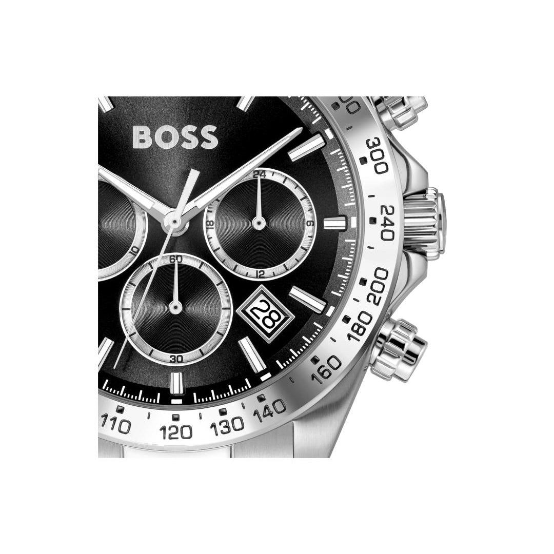 A close-up of a Hugo Boss chronograph watch with a black dial, silver-tone case, and black tachymeter bezel, shown against a plain white background.