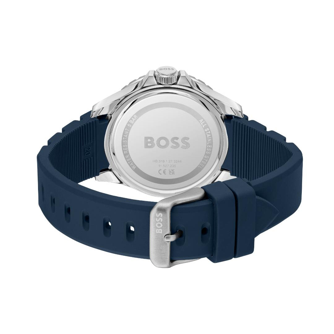 The back view of a HUGO BOSS watch with a navy blue silicone strap and a silver stainless steel case, showing the brushed metal case back engraved with the BOSS logo.