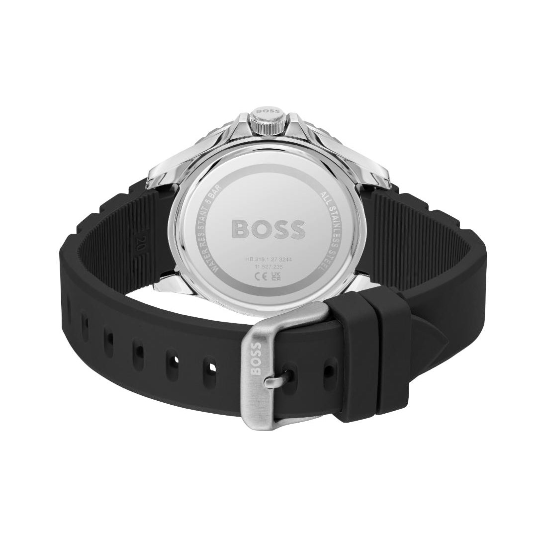 The back view of a HUGO BOSS watch with a navy blue silicone strap and a silver stainless steel case, showing the brushed metal case back engraved with the BOSS logo.