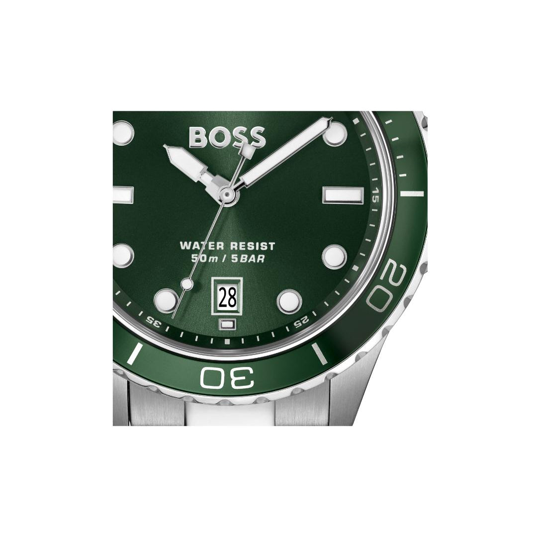 A close-up of a BOSS watch with a dark green dial and bezel, silver-tone stainless steel case and bracelet, and white hour markers.