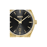 A Hugo Boss men's watch featuring a gold-tone fluted case, a black dial with gold-tone indices and hands, and a date window at the 3 o'clock position.