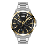 A Hugo brand stainless steel watch with a black dial, gold-tone bezel and hands, and a silver-tone metal link bracelet, shown against a plain white background.