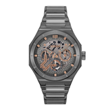 A men's skeleton watch by Ugo with a dark gray metallic case and integrated link bracelet, featuring a detailed dark gray dial with rose gold accents, indices, and hands.