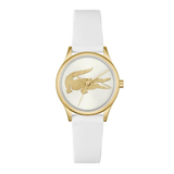 A luxury watch featuring a white textured strap, a gold-tone case, and a white dial with a gold-tone Lacoste crocodile logo.