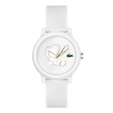 A white Lacoste watch with a textured white silicone strap, featuring a white dial with gold script hands, a green crocodile logo, and the word 'LACOSTE' printed below the 12 o'clock mark.