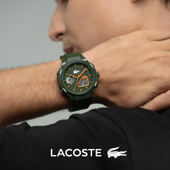 A man wearing a green Lacoste watch with orange accents on the dial and strap, shown in a close-up lifestyle shot with the Lacoste logo and crocodile emblem at the bottom.
