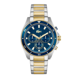 A luxury two-tone stainless steel and gold watch with a textured blue dial, blue bezel, and matching blue strap links, featuring the Lacoste crocodile logo.