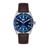 Lacoste watch with a blue dial, silver-tone stainless steel case, and a dark brown perforated leather strap, shown against a plain white background.
