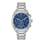 A silver-tone stainless steel chronograph watch by Lacoste with a blue dial, blue bezel, silver-tone case, and matching steel link bracelet. The dial features the iconic green crocodile logo at the 12 o'clock position.