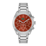 A silver-tone stainless steel chronograph watch by Lacoste with a vibrant orange-red dial, featuring three sub-dials and the iconic green crocodile logo at the 12 o'clock position.