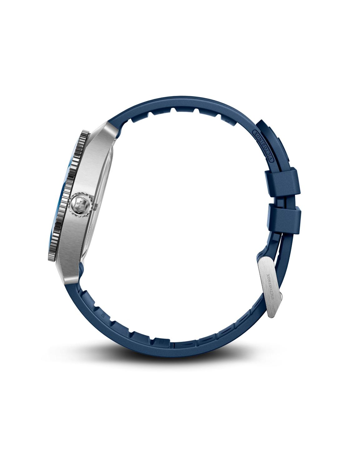 A close-up side view of a watch with a dark blue silicone strap and a silver-toned metal case, shown against a plain white background.