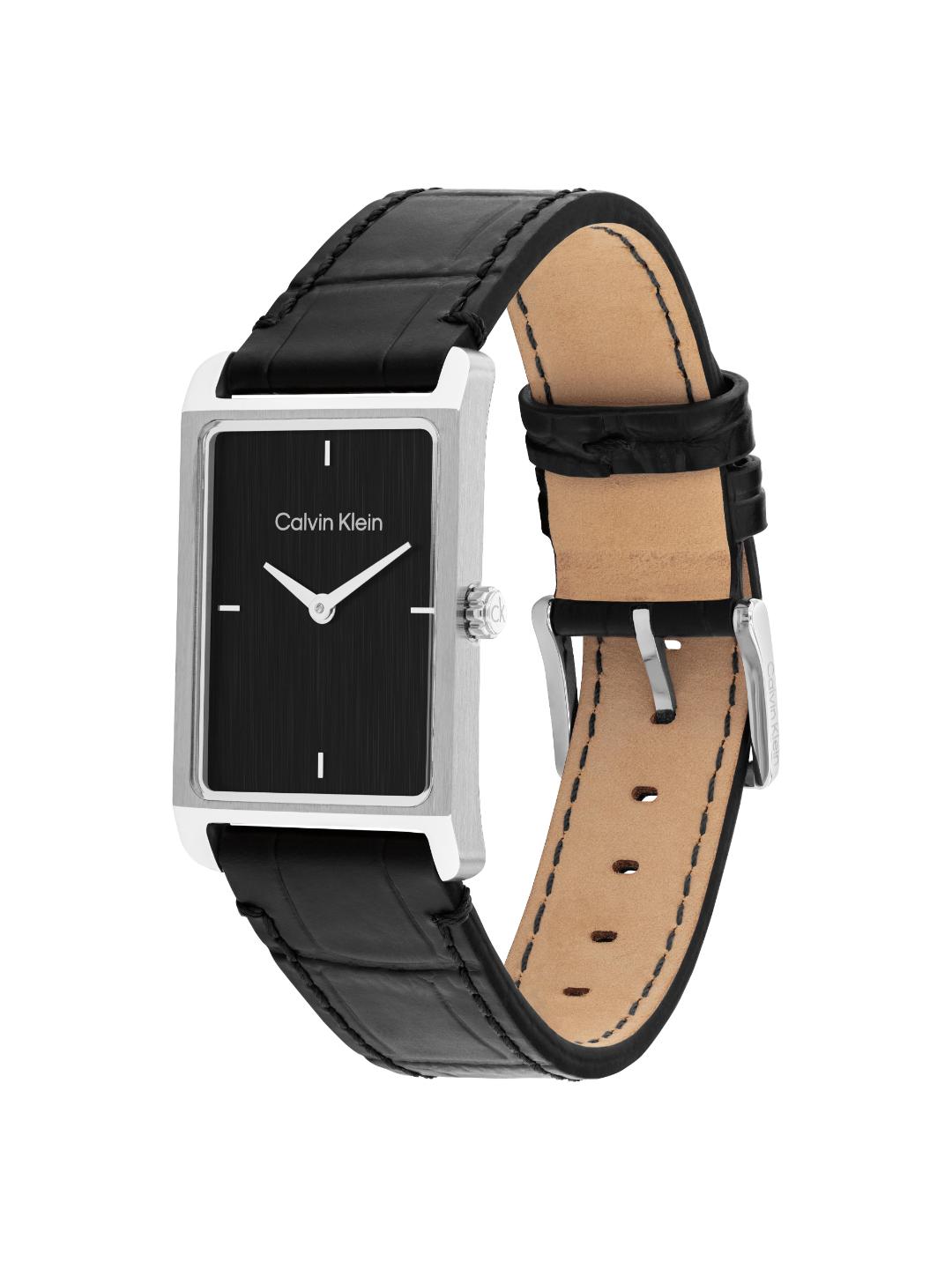 Calvin Klein watch with a rectangular black dial, silver-tone case, and black leather strap with tan interior, shown on a white background.