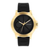 Calvin Klein analog watch with a round gold-tone case, black dial, and black silicone strap, shown on a plain white background.