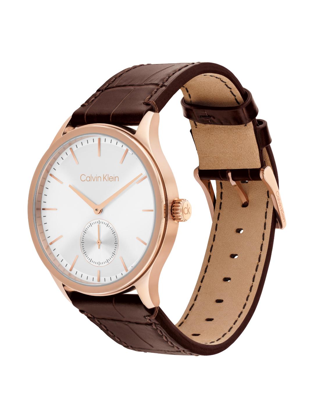Calvin Klein watch with a white dial, rose gold case, and brown leather strap, shown on a clean white background.