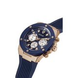 A GUESS men's chronograph watch featuring a rose gold-tone case, a dark blue bezel and dial, and a dark blue textured silicone strap, shown on a plain white background.