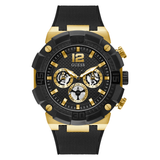 A Guess brand analog men's watch with a black dial, gold case, and a silicone strap.
