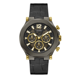 A GUESS men's chronograph watch featuring a dark gunmetal gray case, a black dial with gold-tone subdials and markers, and a black textured strap with gold-tone accents.