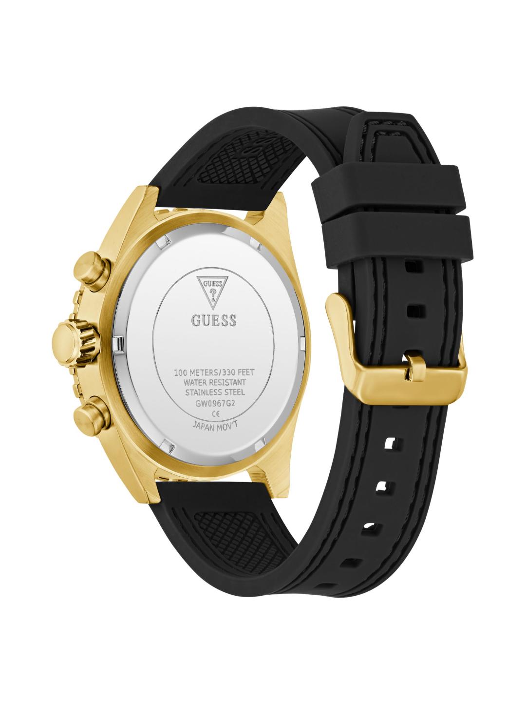 The back view of a GUESS watch with a gold-tone case, silver-tone case back, and a textured black rubber strap on a white background.