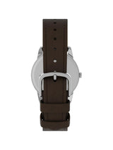 A close-up rear view of a watch with a dark brown leather strap and a silver-toned metal case on a plain white background.
