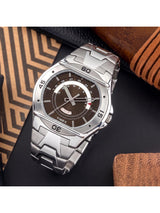 Silver Timex watch with a brown face on a dark surface with a textured brown background