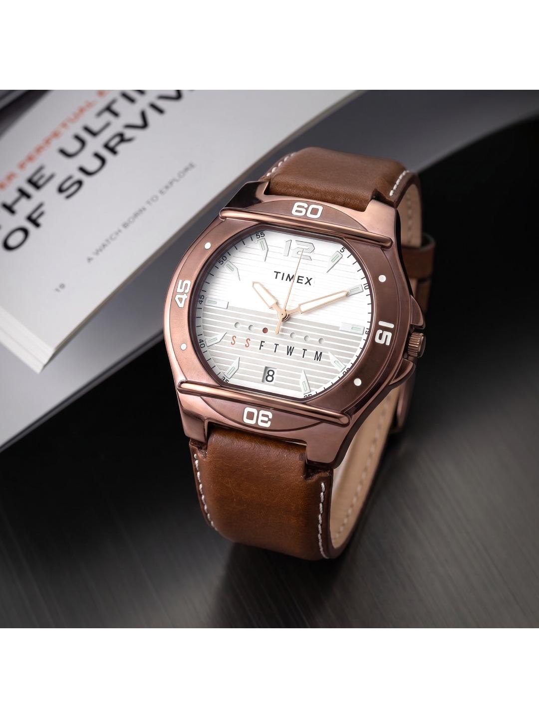 Timex watch with brown leather strap on a dark surface