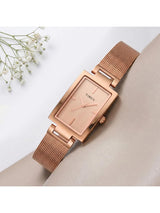 Rose gold watch with mesh band on a light background