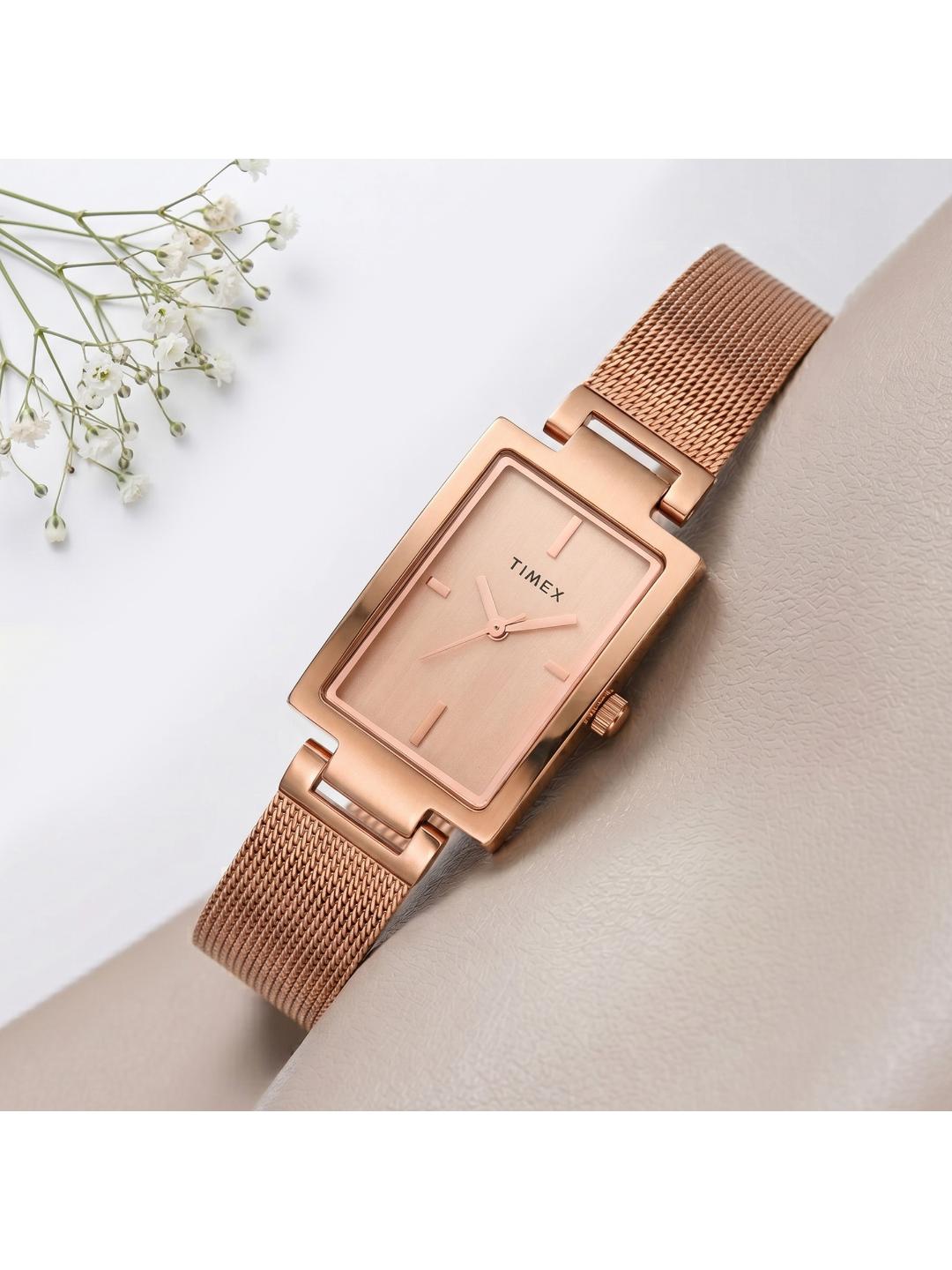 Rose gold watch with mesh band on a light background