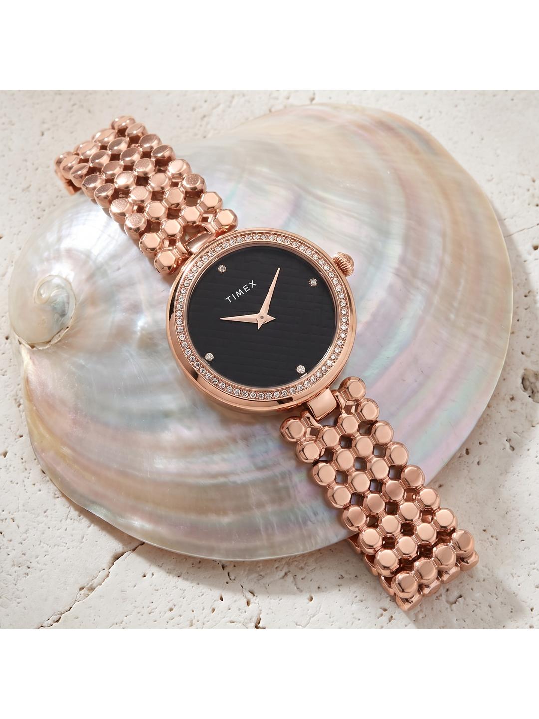 Rose gold watch with black dial on a shell background