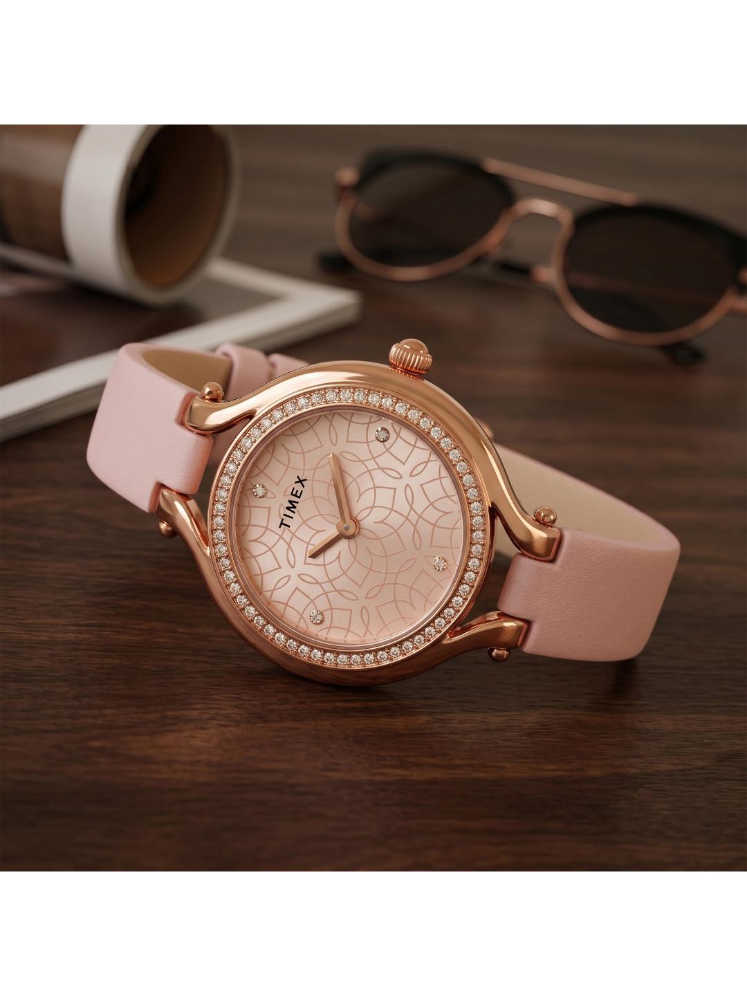 Pink Timex watch with rose gold accents on a wooden surface