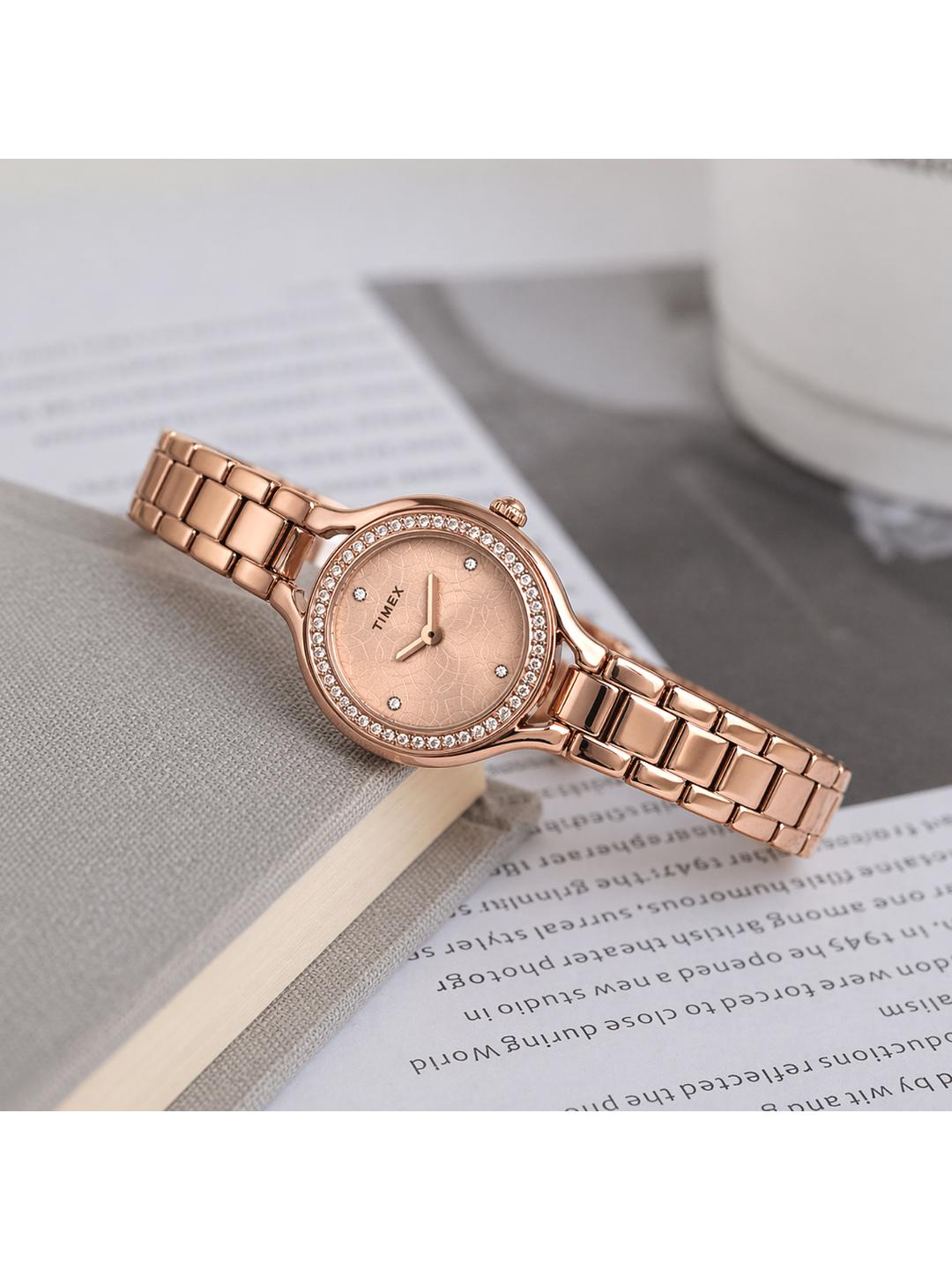 Rose gold watch with diamond accents on a surface