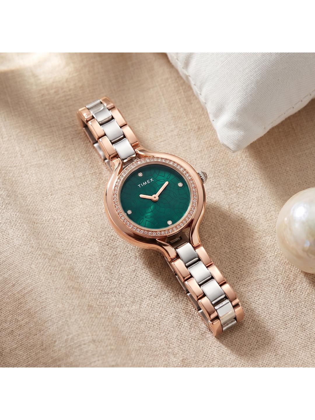 Two-tone watch with a green face on a beige fabric background