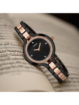 Timex watch with black and rose gold band on sheet music background