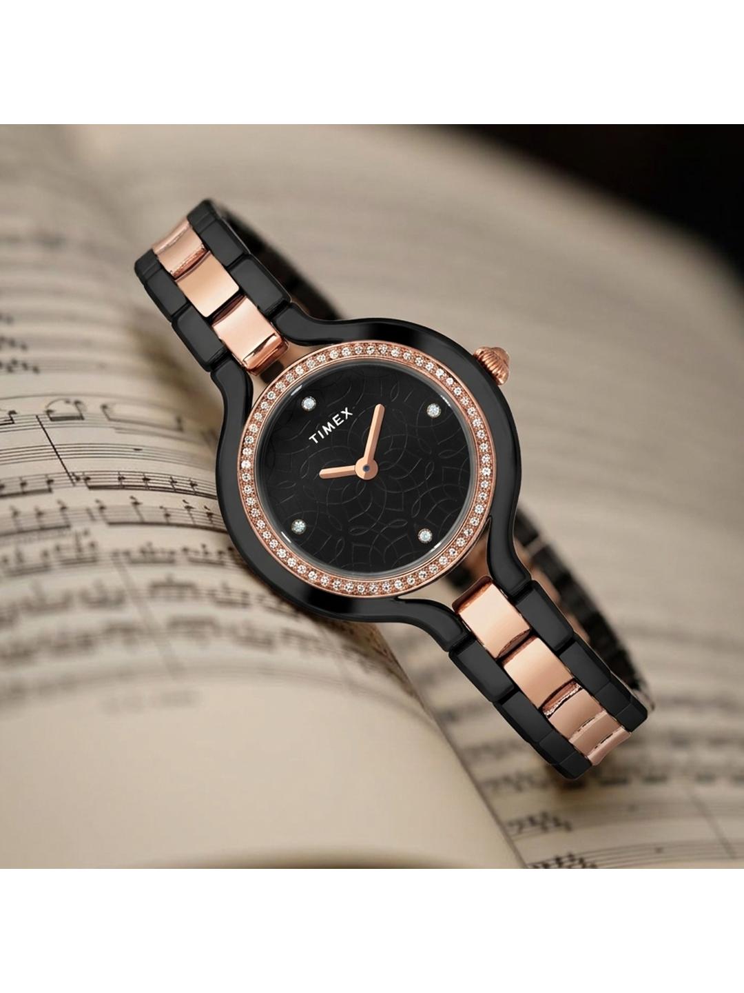 Timex watch with black and rose gold band on sheet music background