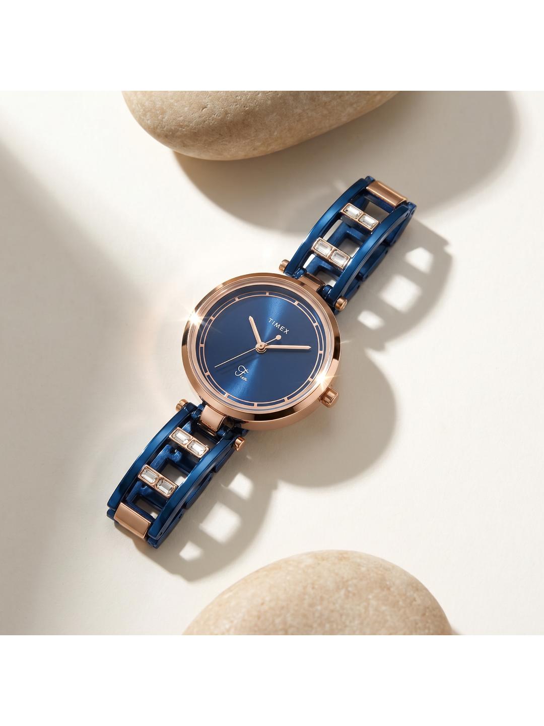 Blue watch with rose gold accents on a light background