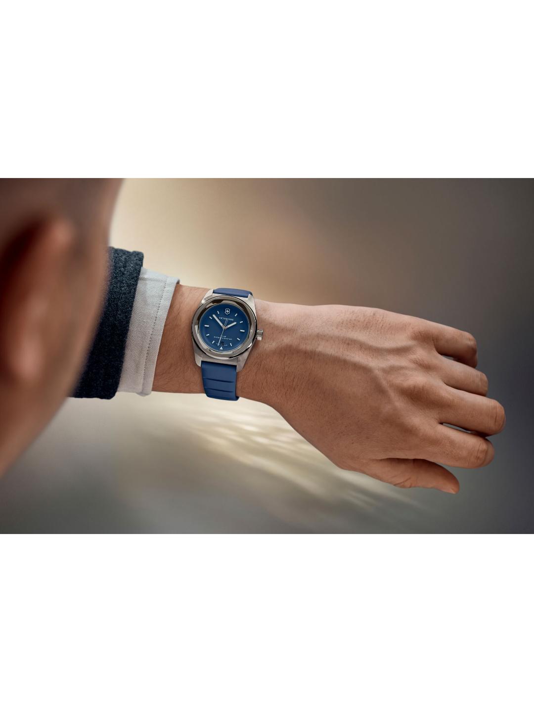 Person wearing a blue watch on a neutral background