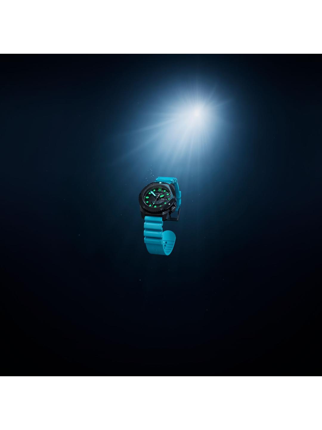 Watch with a blue strap floating in water under a spotlight